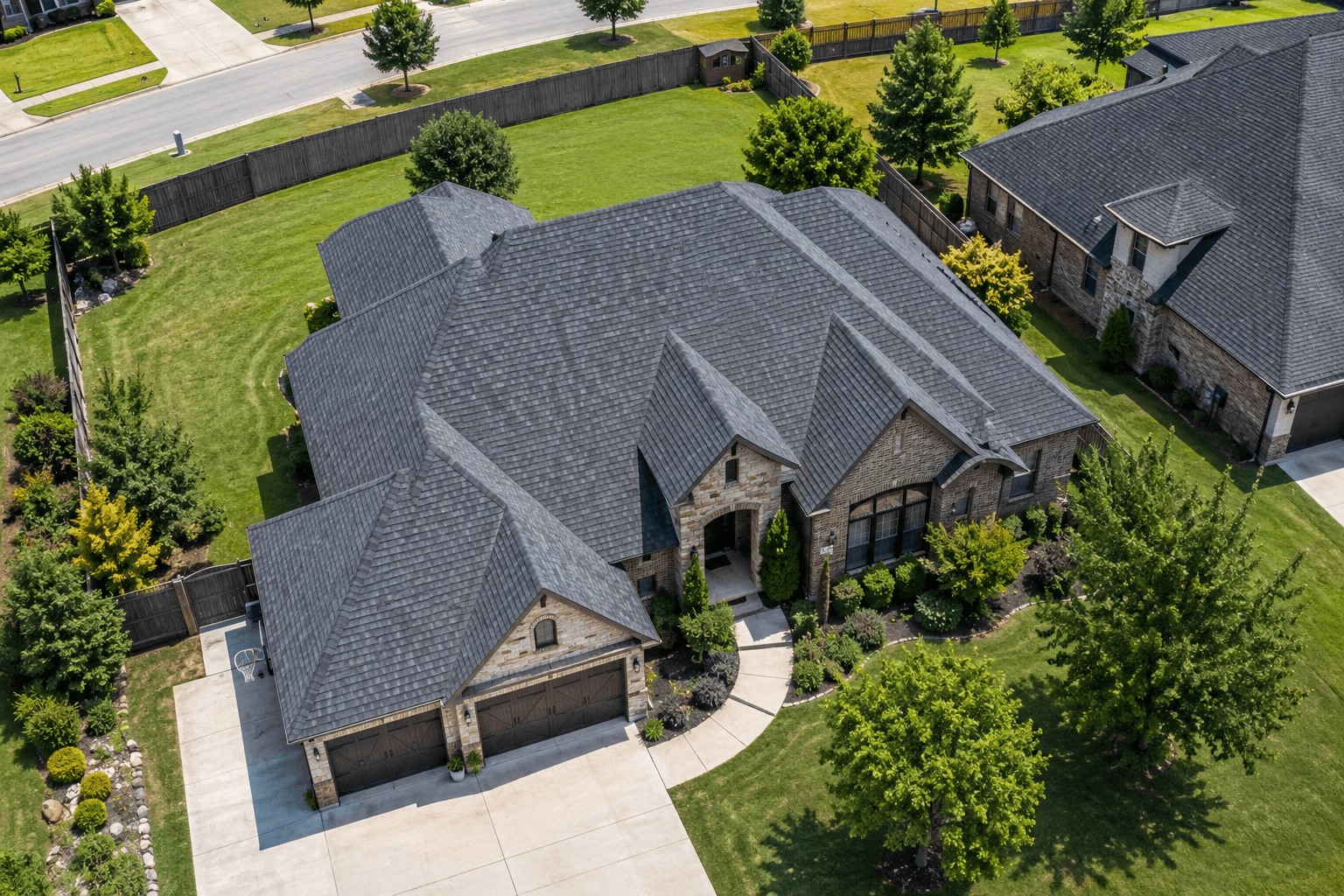 Aerial view of a well-maintained residential home with a new asphalt shingle roof in a suburban neighborhood.
