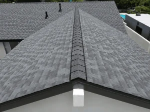 A close-up view of a gray asphalt shingle roof showing the ridge cap