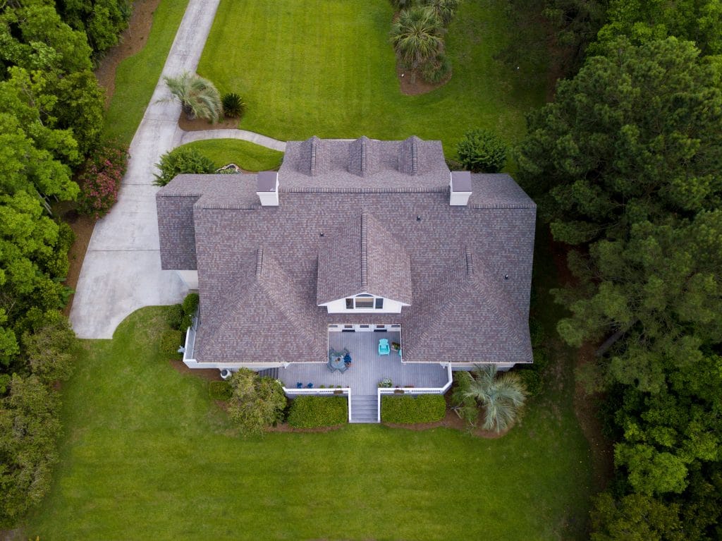 storm damage edmond ok Aerial view of large home with new roof on beautiful property.