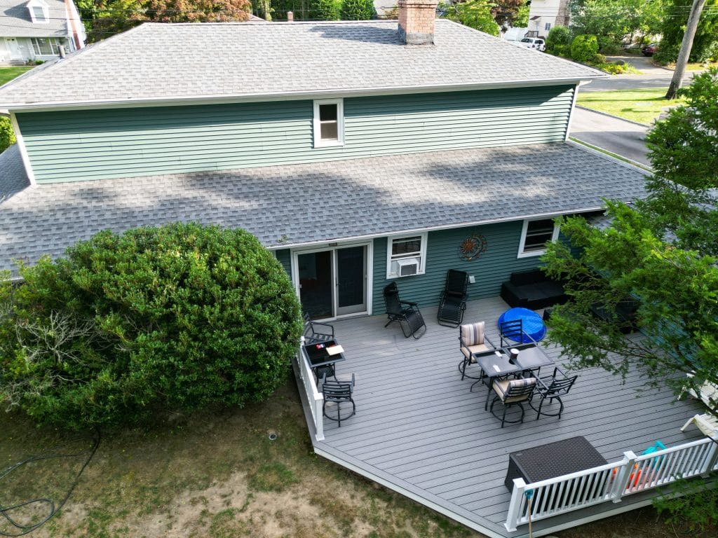 Looking down at backyard with a composite deck on a residential house from a drone.
