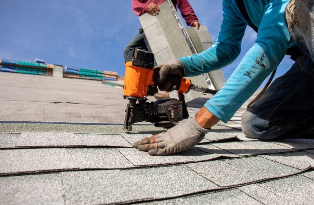 worker installing shingles